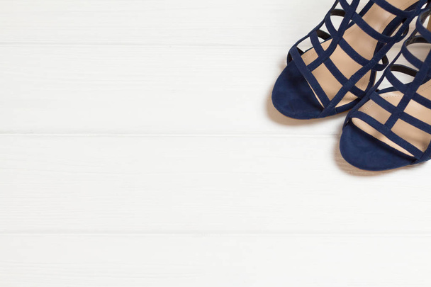 Голубые сандалии на белом деревянном фоне, место для текста, копирайт
 - Фото, изображение