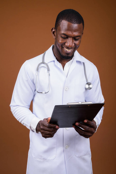 schöner afrikanischer Mann Arzt vor braunem Hintergrund - Foto, Bild