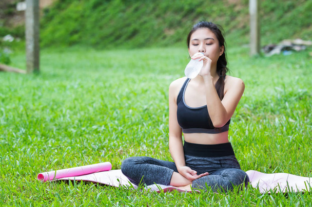 Menina fitness saudável atraente com água potável após o treino de ioga
. - Foto, Imagem