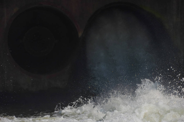 Water released from the dam through pipes into the canal. - Photo, Image