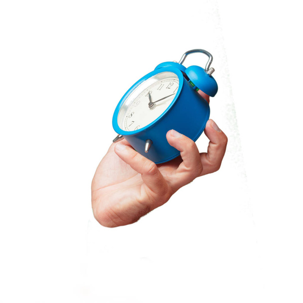 απομονωμένη cutout αρσενικό χέρι κρατά ένα ρολόι συναγερμών - Φωτογραφία, εικόνα