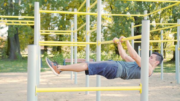 Hombre muscular haciendo ejercicios en la barra horizontal
 - Foto, imagen