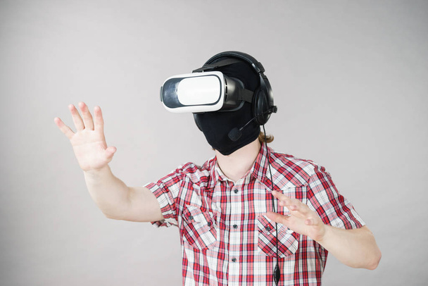 Man playing video game wearing virtual reality device. Gaming equipment for gamers concept. - Fotografie, Obrázek