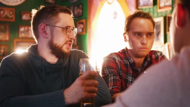 Trzech młodych mężczyzn, picia piwa w pubie - Materiał filmowy, wideo