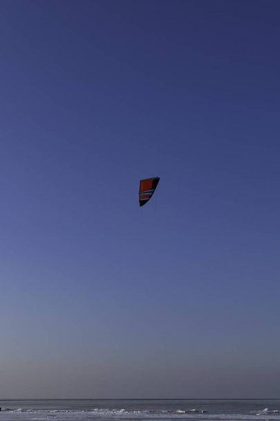Snowboarder with a kite on the sea in the winter. The concept of winter sports. - Photo, Image