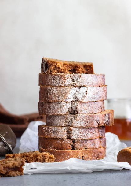Spicy honey cake with sugar powder served on grey concrete background. Honey cake for Rosh Hashanah. Copy space. - Foto, Imagen