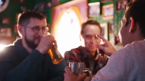 Three guys drinking beer in a pub and discuss something. - Footage, Video