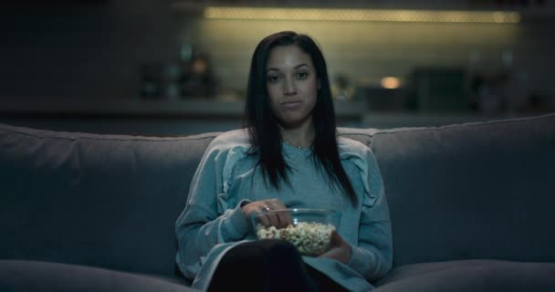 Girl at home watching a late night movie, relaxing, eating popcorn. - Filmagem, Vídeo