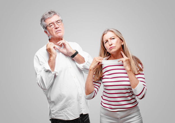 senior cool husband and wife with an anxious, stressed and nervous gesture, feeling under great pressure. - Photo, Image
