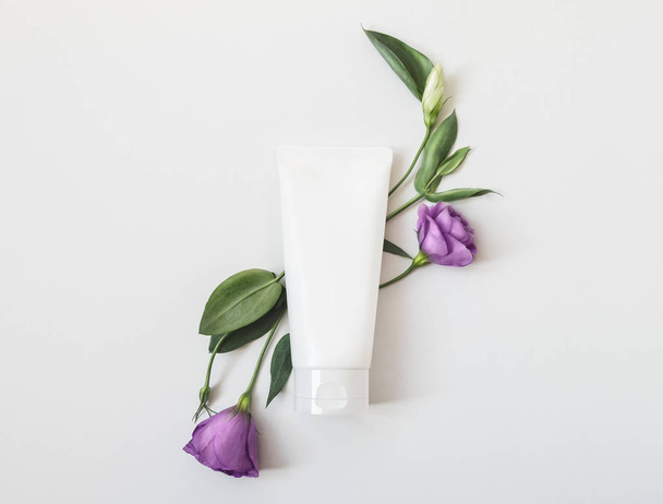 Emballage cosmétique bio naturel maquillé avec des feuilles et des fleurs. Bouteille maquillante pour marque et étiquette
 - Photo, image