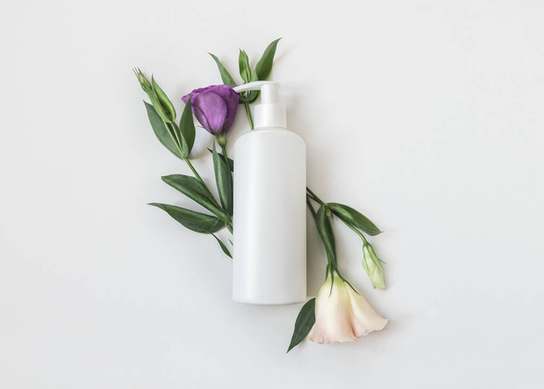 Natural organic cosmetic packaging plastic mock up with leaves and flowers. Mock-up bottle for branding and label - Photo, Image