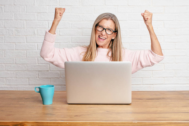 senior businesswoman Gesturing victory, with a happy, proud and satisfied look on face and both arms in the air with fists pressed showing strength or success, celebrating an achievement. - Foto, Imagen