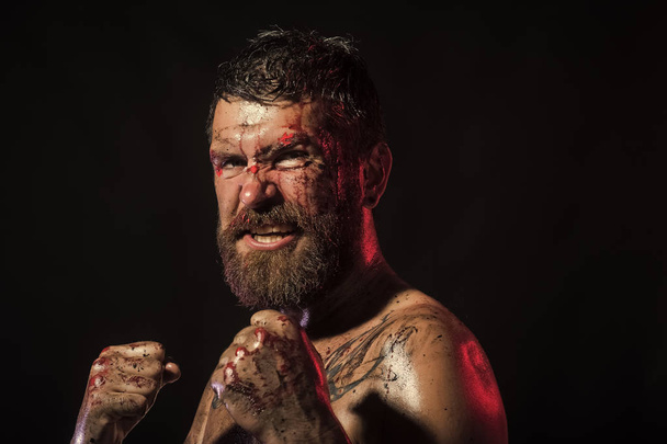Bearded man with blood paint on angry face - Фото, изображение