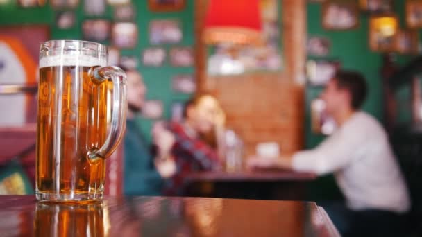 Guy friends drinking beer on the background. Pint of beer in focus - Footage, Video