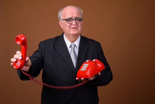 Portrait of overweight senior businessman talking on phone - Zdjęcie, obraz