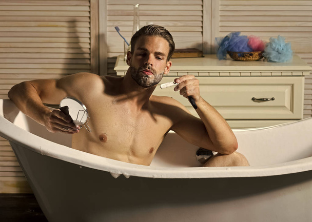 Young attractive man shaves in mirror - Fotó, kép