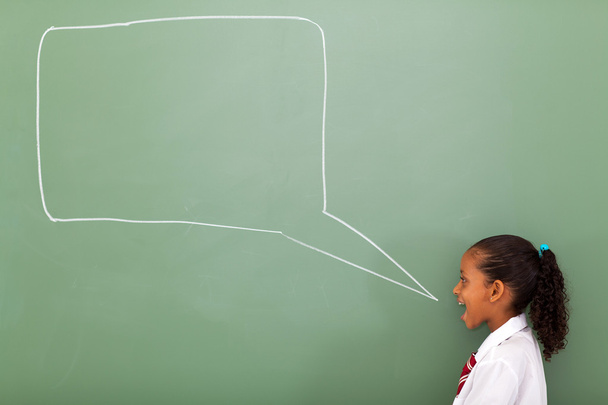 Elementary schoolgirl with speech bubble drawn on chalkboard - Photo, Image
