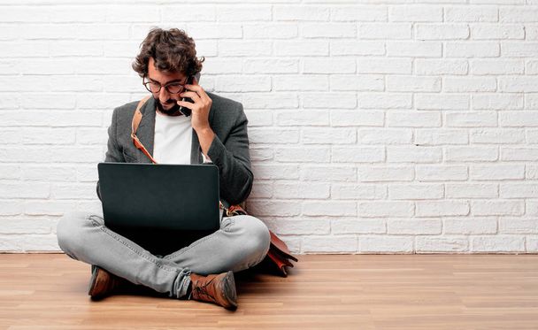 young bearded businessman sitting on floor with a laptop - 写真・画像