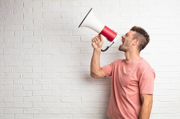young handsome cool man holding a megaphone - Foto, imagen