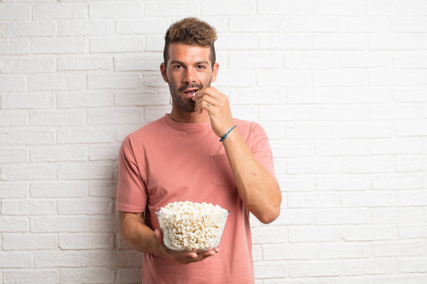 young handsome cool man with popcorns. movie or film concept - 写真・画像