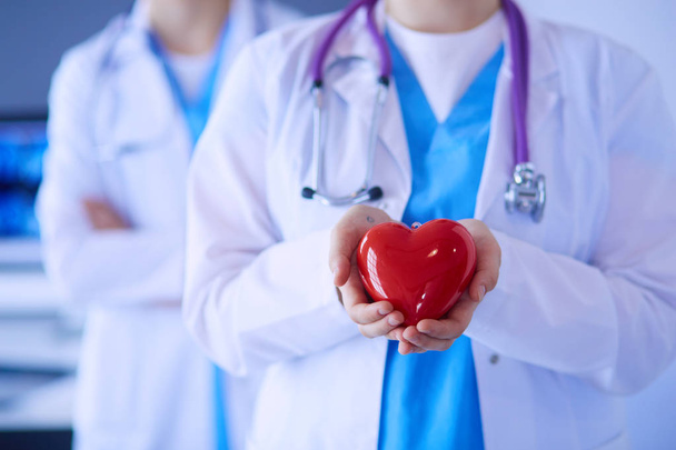Cropped shoot of two young doctors female with stethoscope holding heart. - 写真・画像