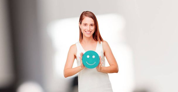 young pretty woman with a smiley emoticon - Фото, изображение