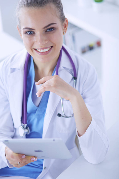 Close-up Portret van vriendelijke vrouwelijke arts met stethoscoop en tablet in handen. - Foto, afbeelding