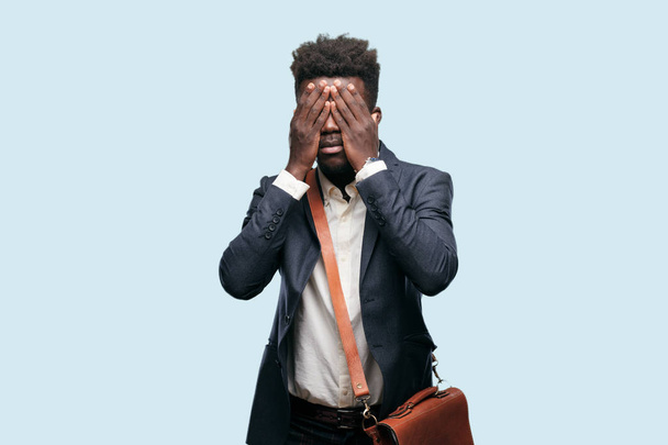 young black businessman with a serious, scared, frightened expression, covering eyes with both hands. - Fotografie, Obrázek