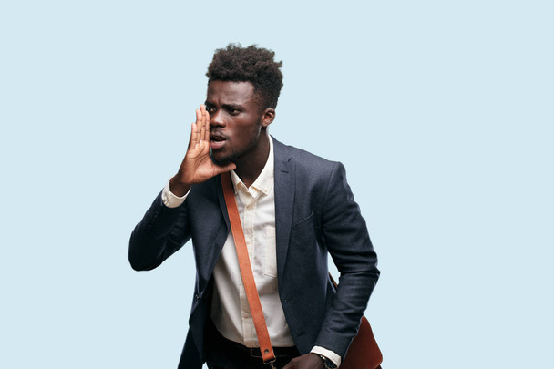 young black businessman shouting loud like crazy, calling with hand with an angry expression, communicating a big announcement. - Фото, изображение