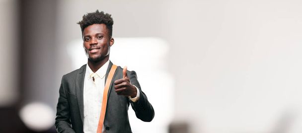 young black businessman with a satisfied, proud and happy look with thumbs up, signaling OK with one hand, sending a positive, "alright' message. - Foto, Imagem