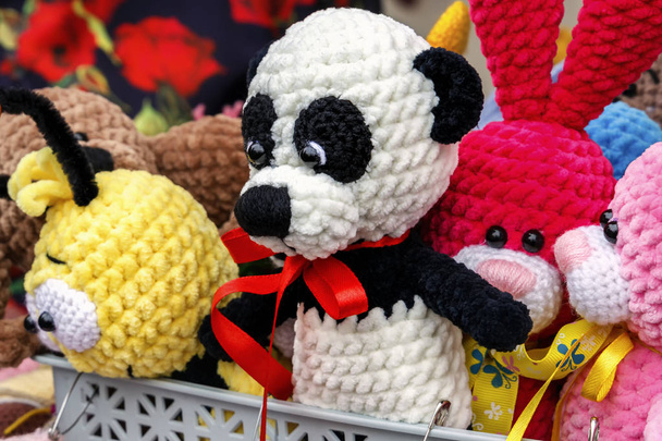 Coloridos juguetes hechos a mano de punto están en exhibición para la venta en una tienda de recuerdos en el mercado. Primer plano
 - Foto, imagen