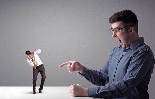 Young businessman fighting with miniature businessman - Foto, Imagem