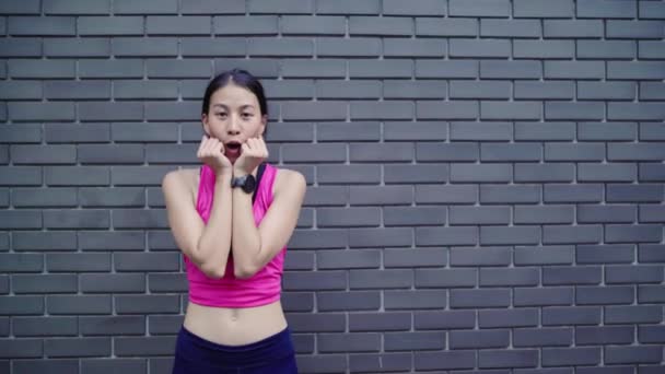 Gezonde mooie jonge Aziatische runner vrouw gevoel gelukkig lachen en kijken naar de camera na het uitvoeren van op straat in stedelijke stad. Levensstijl passen en actieve vrouwen uitoefenen in het concept van de stad. - Video