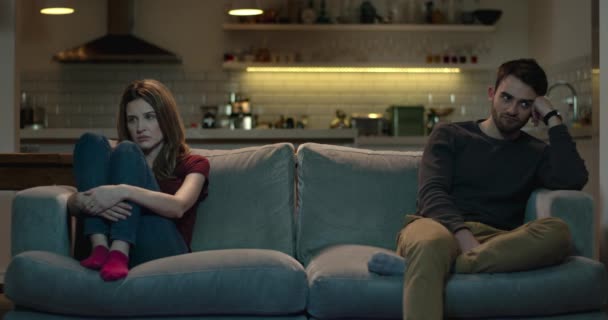 Couple sit apart on a sofa after an argument. - Πλάνα, βίντεο