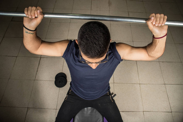 Homem exercitando com halteres, exercício no ombro
 - Foto, Imagem