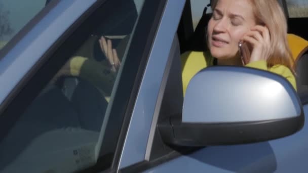 triest charmante business womanin een auto eist op mobiele telefoon. 4k - Video