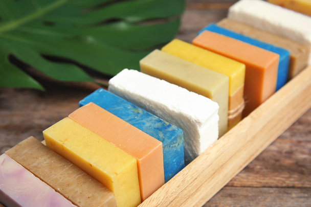 Many different handmade soap bars in wooden box on table, closeup - Foto, Imagen