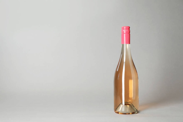 Bottle of wine on grey background. Space for text - Zdjęcie, obraz