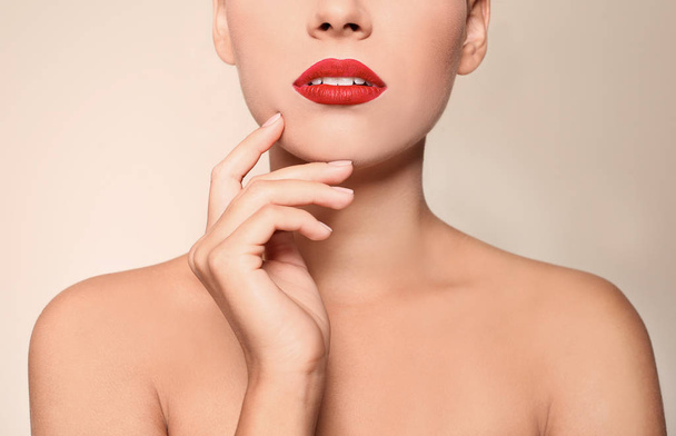 Beautiful young woman with red lips on color background, closeup - Fotografie, Obrázek