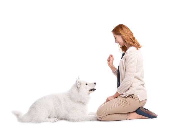Beautiful woman with her cute dog on white background - Φωτογραφία, εικόνα