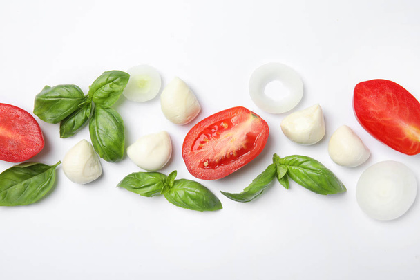 Fresh green basil leaves, tomatoes and mozzarella on white background, top view - Foto, imagen