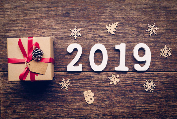 Вид сверху деревянные номера, образующие номер 2019, на новый 2019 год на деревенском деревянном с подарочной коробкой и красной лентой и рождественской отделкой
. - Фото, изображение