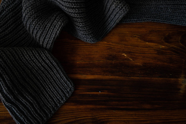 Винтажный вязаный шарф на старом деревянном фоне с копировальным пространством
 - Фото, изображение