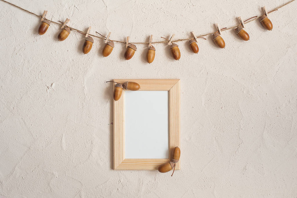 Autumn composition with wooden frame. Acorn with clothespins on clothes line rope. Wooden pegs. Flat lay, top view, copy space. - Fotoğraf, Görsel