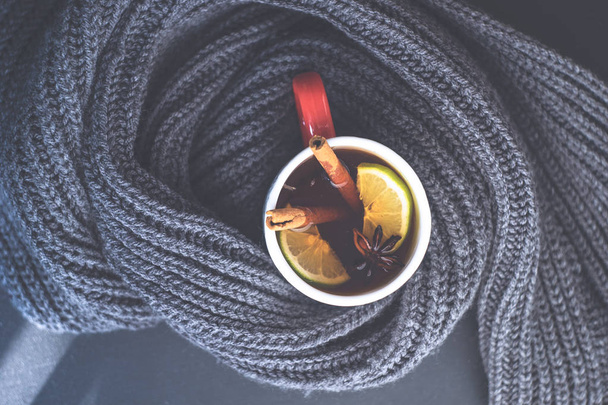 Winter hot mulled tea with lemon and spices and warm knitted scarf - Фото, зображення