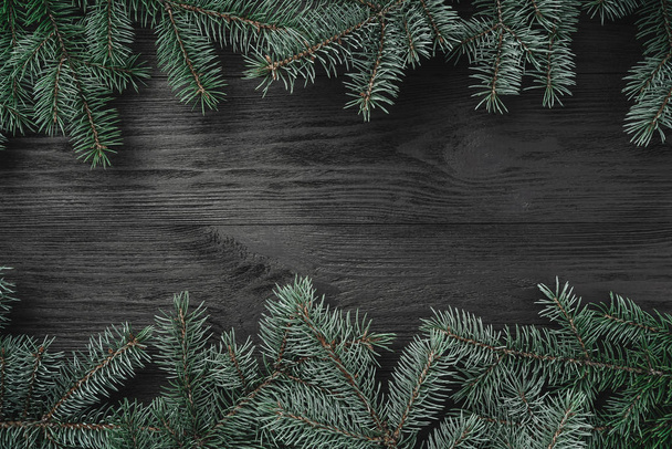 Noel kartı. Siyah ahşap zemin çam dalları alt ve üst. Üstten görünüm - Fotoğraf, Görsel