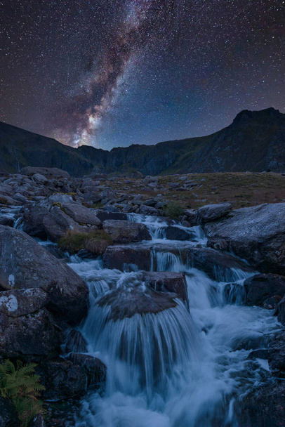 Εκπληκτική ζωντανή σύνθετη εικόνα του Milky Way πάνω από την εικόνα του τοπίου του ποταμού που ρέει κάτω οροσειράς κοντά Llyn Ogwen και Llyn Idwal σε Snowdonia - Φωτογραφία, εικόνα