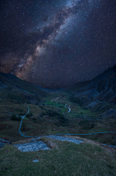Stunning vibrant Milky Way composite image over Beautiful moody landscape image of Nant Francon valley in Snowdonia - Photo, image