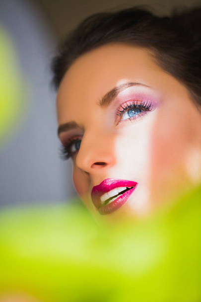 Beautiful face of woman with makeup and conceived glance on which sun shines - 写真・画像