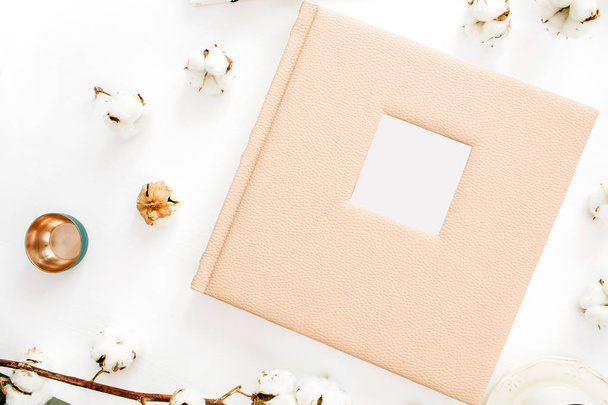 Family or wedding photo album with blank space for text, cotton buds, decoration on white background. Flat lay, top view. - Photo, Image